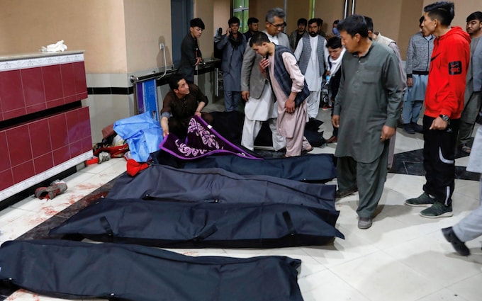 مردان افغان پس از بمب گذاری به دنبال بستگان خود در بیمارستان می روند